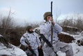 ウクライナ東部ドネツク州ベルヒノトレーツケ村付近の親ロシア分離独立派との前線にある塹壕の近くで、小型望遠鏡を使って周囲を監視するウクライナの兵士（2022年1月31日撮影）。(c)Anatolii STEPANOV / AFP