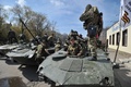 ウクライナ東部ドネツク（Donetsk）州スラビャンスク（Slavyansk）の親ロシア派の分離派勢力によって占拠された行政庁舎の前で、装甲車の周囲に集まる軍服を着た武装集団（2014年4月16日撮影）。(c)AFP/GENYA SAVILOV