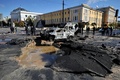 ウクライナの首都キーウで、ロシアによる攻撃で破壊された車を調べる警察（2022年10月10日撮影）。(c)SERGEI CHUZAVKOV / AFP