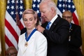 米ホワイトハウスでジョー・バイデン大統領（右）から大統領自由勲章を授与されるミーガン・ラピノー（2022年7月7日撮影）。(c)SAUL LOEB / AFP