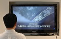 韓国・ソウルで開催された「グリーン成長とグローバルゴールズ2030のためのパートナーシップ（P4G）」首脳会議について報じるニュースで映し出された、北朝鮮の首都平壌の画像を見る男性（2021年6月1日撮影）。(c)Jung Yeon-je / AFP