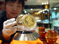 中国北部陝西省（%%Shaanxi%%）西安（%%Xian%%）市内の宝石商で、金製の装飾品を展示する店員（2008年3月30日撮影）。(c)AFP