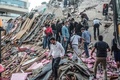 トルコのイズミルで、地震により倒壊した建物で行方不明者の捜索を行う人々（2020年10月30日撮影）。(c)MERT CAKIR / AFP