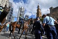 豪シドニーで行われたロックダウンに抗議するデモの対応に動員された警察の騎馬隊（2021年7月24日撮影）。(c)Steven SAPHORE / AFP