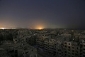 シリアの首都ダマスカス近郊の反体制派支配地区、東グータのイルビンで、政府軍による空爆で現れた光と煙（2018年3月11日撮影）。(c)AFP PHOTO / Ammar SULEIMAN