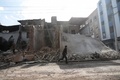 シリアの首都ダマスカス東郊にある反体制派が掌握するドゥーマ地区で、停戦が発効した初日、破壊された建物のそばを通り過ぎる少年（2016年12月30日撮影）。(c)AFP/Abd Doumany