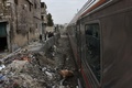 シリア・アレッポ東部で、荒廃した地区を走行する列車を眺める人たち（2017年1月25日撮影）。(c)AFP/George OURFALIAN