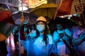 香港の旺角（Mongkok）地区で、傘をさして暴風雨をしのぐ民主派デモの参加者（2014年10月22日撮影）。(c)AFP/ ALEX OGLE