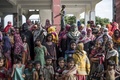 バングラデシュのコックスバザール地区にある学校で、ロヒンギャ難民の遺体の到着を見つめる人々（2017年9月29日撮影）。(c)AFP/FRED DUFOUR