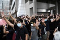 「覆面禁止規則」違反の罪で起訴されたデモ参加者2人が出廷した香港東区の裁判所でスローガンを叫ぶ民主派の活動家ら（2019年10月7日撮影）。(c)Mohd RASFAN / AFP