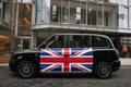 英ロンドンの充電スタンドで停車中の新型電気タクシー「TX eCity」（2017年12月5日撮影）。(c)AFP/Daniel LEAL-OLIVAS