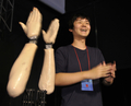 東京・江東区の日本科学未来館（National Museum of Emerging Science and Innovation）で開催中の「デジタルコンテンツエキスポ（Digital Content Expo）」のオープニングで拍手をするロボットアーム「音手（おんず）」と、開発した慶應大学大学院メディアデザイン研究科の高橋征資（Masato Takahashi）さん(2011年10月20日撮影)。(c)AFP/Yoshikazu TSUNO