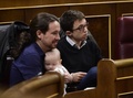 スペインで招集された下院議会で、新興政党ポデモスのカロリーナ・ベスカンサ議員（写真外）が連れてきた赤ちゃんを抱く同党のパブロ・イグレシアス書記長（左、2016年1月13日撮影）。(c)AFP/PIERRE-PHILIPPE MARCOU