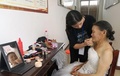 写真撮影のためウエディングドレスをまとい、化粧をする女性（2019年7月26日撮影）。(c)CNS/張祖強
