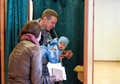 ラトビアのオグレで、議会選挙の投票を行う一家（2018年10月6日撮影）。(c)Ilmars ZNOTINS / AFP