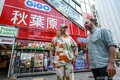 東京・秋葉原で、中古ゲームショップ巡りをするリュドビク・シャルルさん（右）とブノア・テブニさん（2023年10月10日撮影）。(c)Richard A. Brooks / AFP