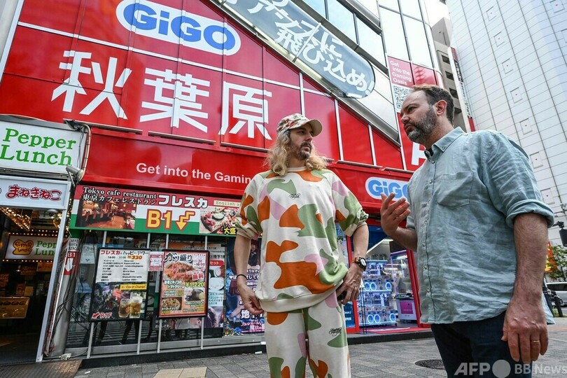 東京・秋葉原で、中古ゲームショップ巡りをするリュドビク・シャルルさん（右）とブノア・テブニさん（2023年10月10日撮影）。(c)Richard A. Brooks / AFP
