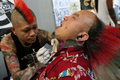 ロンドン（London）で25日から第5回「ロンドン・タトゥー・コンベンション（London Tattoo Convention）」が開催され、米国、オーストラリア、カナダ、日本、英国から多数のタトゥーアーティストが参加した。会場にはタトゥー愛好家やボディピアスの専門家、ファッションデザイナーなどの姿も見られた。主催者によると、本大会では「1か所で新たにタトゥーを施した人の数」で世界最多記録の樹立を目指しているという。

写真は、ロンドンで開催された第5回「ロンドン・タトゥー・コンベンション」でタトゥーを施すタトゥーアーティスト（左、2009年9月25日撮影）。(c)AFP/Tal Cohen
