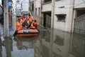 インド・ハイデラバードの豪雨で冠水した通りで、ボートを使って住民を避難させる国家災害対応部隊の隊員ら（2020年10月15日撮影）。(c)NOAH SEELAM / AFP