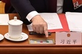 中国・北京の人民大会堂で開かれた全国人民代表大会（全人代）で、香港の選挙制度改革に関する議案の投票に臨む習近平国家主席の手元（2021年3月11日撮影）。(c)NICOLAS ASFOURI / AFP