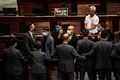 香港立法会（議会）で、中国国歌への侮辱行為に罰則を科す国歌条例案の審議中に、警備担当者らともみ合いになる民主派議員ら（2020年6月4日撮影）。(c)ISAAC LAWRENCE / AFP