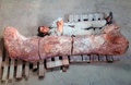 アルゼンチンのチュブト（Chubut）州ラウソン（Rawson）で発見された、世界最大とみられる恐竜の大腿（だいたい）部の化石と、大きさを比べるため横になっている発掘要員（2014年5月16日撮影）。(c)AFP/TELAM/Museo Egidio Feruglio