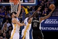 15-16NBA、ゴールデンステイト・ウォリアーズ対サンアントニオ・スパーズ。ゴールデンステイト・ウォリアーズのドレイモンド・グリーン（中央）のブロックをかわしながら、シュートを放つサンアントニオ・スパーズのカウィ・レナード（右、2016年4月7日撮影）。(c)AFP/Getty Images/Thearon W. Henderson