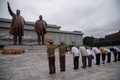 北朝鮮・平壌で、朝鮮戦争の停戦から67年を記念し、故金日成氏と故金正日氏の像に向かって礼をする人々（2020年7月27日撮影）。(c)KIM Won Jin / AFP