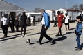 ギリシャ・アテネのエレオナス移民・難民キャンプで、若者や子どもたちとサッカーに興じる国際オリンピック委員会（IOC）のトーマス・バッハ会長（2016年1月28日撮影）。(c)AFP/ARIS MESSINIS