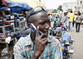 ナイジェリア・ラゴス（Lagos）で、バイクに乗ったまま携帯電話で話す男性（2008年8月18日撮影）。(c)AFP/PIUS UTOMI EKPEI