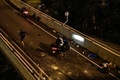 香港理工大学の構内から脱出するため、歩道橋から幹線道路へロープで下り、待機するバイクに乗るデモ参加者（2019年11月18日撮影）。(c)AFP/Anthony WALLACE
