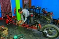 インド北東部トリプラ州アガルタラ郊外の自宅のガレージで、対人距離を確保することができるバイクを組み立てるパルタ・サハさん（撮影日不明）。(c)Abhisek SAHA / AFP