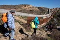 メキシコ・バハカリフォルニア州ティフアナで、国境フェンスを越えようとする中米移民（2018年12月30日撮影）。(c)GUILLERMO ARIAS / AFP