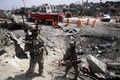 アフガニスタンの首都カブールで、前夜にグリーン・ビレッジで起きた爆発によって地面に開いた穴の周辺に集まる治安部隊や自治体職員ら（2019年9月3日撮影）。(c)STR / AFP