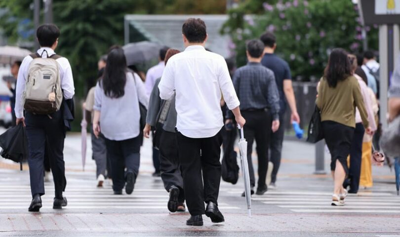 7日、ソウル・光化門交差点で、降ったりやんだりする雨の中、傘を手に出勤する市民ら(c)news1/MONEYTODAY