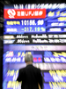 都内で、株価を示す電光ボードを眺める男性（2008年10月7日撮影）。(c)AFP/Yoshikazu TSUNO
