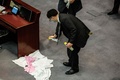 香港立法会（議会）で、中国国歌への侮辱行為に罰則を科す国歌条例案の審議中に、民主派議員が投げた悪臭を放つ液体の清掃に当たる警備担当者（2020年6月4日撮影）。(c)ISAAC LAWRENCE / AFP