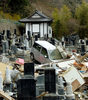 東日本大震災の発生から1か月が過ぎた被災地。写真は宮城県石巻市で、墓地に流された車（2011年4月16日撮影）。(c)AFP/David WATKINS