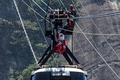 ブラジル・リオデジャネイロ（Rio de Janeiro）で、パン・デ・アスーカル山（Pao de Acucar）にあるロープエーのワイヤロープを滑車で滑り降りるサンタクロース姿の男性（2014年12月18日撮影）。(c)AFP/YASUYOSHI CHIBA