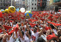 1週間にわたる牛追いが有名なスペイン北部パンプロナ（Pamplona）の祭りサン・フェルミン（San Fermin）が6日正午、「チュピナソ」と呼ばれる花火の打ち上げとともに始まりを告げた。

写真は市庁舎前で行われた「チュピナソ」を祝うために伝統の赤いスカーフを手に集まった人たち（2012年7月6日撮影）。(c)AFP/ANDER GILLENEA
