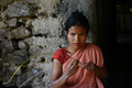 インド・メガラヤ（Meghalaya）州マウシンラム（Mawsynram）村で、竹の葉を割く作業を行う女性（2013年2月3日撮影）。(c)AFP/Roberto SCHMIDT