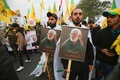 イラクの首都バグダッドで、イラン革命防衛隊のガセム・ソレイマニ司令官と人民動員隊のアブ・マフディ・ムハンディス副司令官の葬列に加わった、人民動員隊や親イラン派武装組織「神の党旅団（カタイブ・ヒズボラ）」の支持者ら（2020年1月4日撮影）。(c)AFP/Ahmad AL-RUBAYE