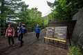 富士山の山梨県側にある吉田ルート5号目に設置されたゲート付近を歩く登山客（2024年7月1日撮影）。(c)Philip FONG / AFP