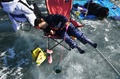 韓国・江原道の華川で開かれた恒例のヤマメ祭りで穴釣りをする子ども（2019年1月5日撮影）。(c)AFP PHOTO / JUNG Yeon-Je