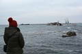 ウクライナ南部クリミア（Crimea）半島西岸にあるドヌズラフ（Donuzlav）湖の黒海（Black Sea）に通じる出入り口部分に沈められたロシア艦艇をみる女性（2014年3月8日撮影）。(c)AFP/KATHERINE HADDON