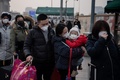 中国・北京で、マスクをしてタクシー待ちの列に並ぶ人々（2020年1月27日撮影）。(c)NICOLAS ASFOURI / AFP