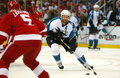 写真は、パックをキープするシャークスのジョー・ソーントン（%%Joe Thornton%%、右）。(c)AFP/Getty Images Dave Sandford