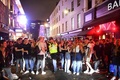 英ロンドンのソーホー地区で、バーの外で飲み騒ぐ人々（2020年7月4日撮影）。(c)JUSTIN TALLIS / AFP