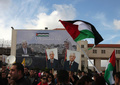 パレスチナ自治区ヨルダン川西岸（West Bank）のラマラ（Ramallah）で、国連での地位格上げ決議案に関するマフムード・アッバス（Mahmud Abbas）自治政府議長の演説を聞く人々。背後の旗には「パレスチナ国家」と書いてある（2012年11月25日撮影）。(c)AFP/ABBAS MOMANI