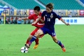 サッカー東アジアカップ、北朝鮮対日本。北朝鮮のロ・ハクス（左）とボールを競る藤春廣輝（2015年8月2日撮影）。(c)AFP/WANG ZHAO